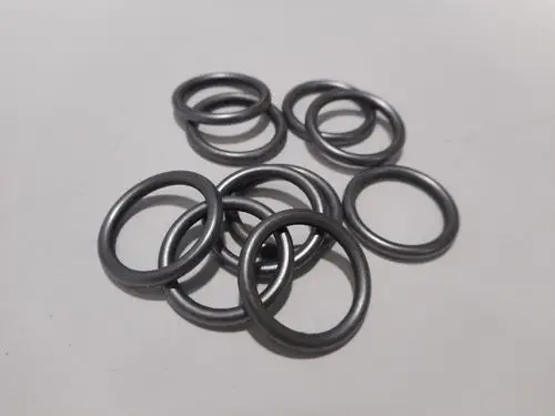 Zahlreiche schwarze O-Ringe liegen verstreut auf einer hellen Oberfläche. Diese O-Ringe sind für Anwendungen von Remeha konzipiert.
